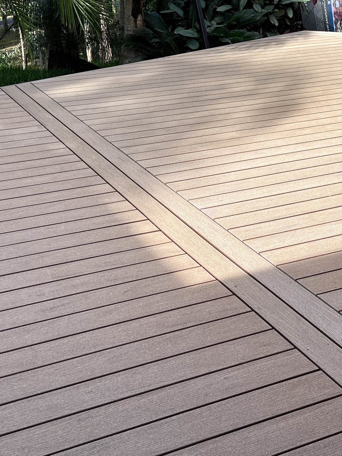 Grey decking boards with a long divider board running across the surface.
